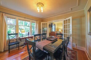 A dining area with a glass table, black chairs, and a red placemat. - Lovely 4BR Lakeview - Game Room - Foosball (Seattle)