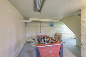 A room with a foosball table, a window, and a barrel. - Lovely 4BR Lakeview - Game Room - Foosball (Seattle)