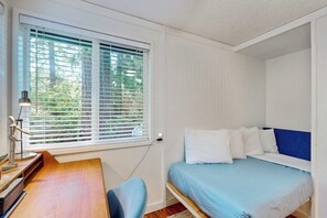 A bedroom with a bed, a desk, and a window with blinds. - 3BR waterfront home with gas grill and deck (Lacey)