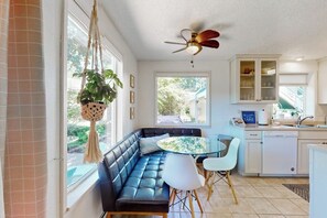 A modern kitchen with a built-in seating area, a ceiling fan, and a view of the outdoors. - 3BR waterfront home with gas grill and deck (Lacey)