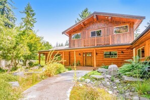 A two-story log cabin with a porch, surrounded by a natural landscape. - Custom 3BR Golf Course View - Chef's Kitchen (Union)