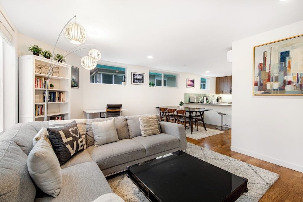A modern living room with a sofa, a coffee table, and a bookshelf.