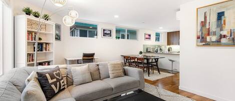 A modern living room with a sofa, a coffee table, and a bookshelf.