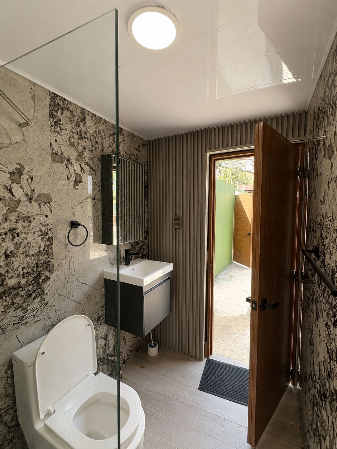 Un baño con inodoro, lavamanos y zona de ducha.
