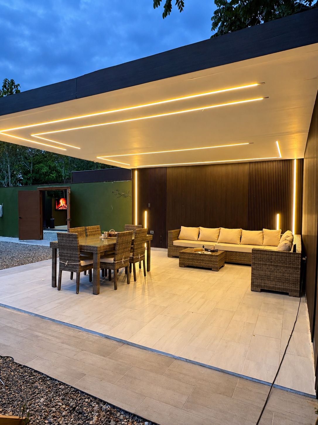 An outdoor living area with a dining set, sofa, and a fire feature.