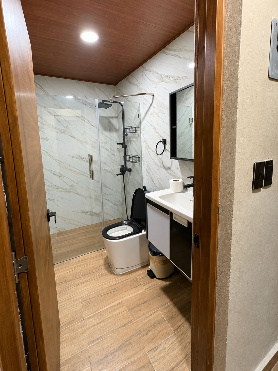 Un baño pequeño con inodoro, ducha y lavamanos.