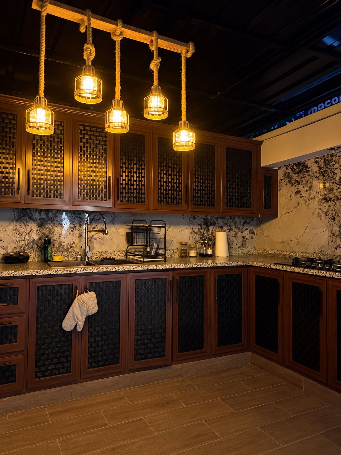 A kitchen with wooden cabinets, a marble backsplash, and pendant lights.