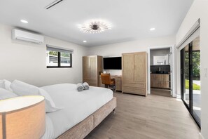 Un dormitorio moderno con cama, escritorio y armario.
