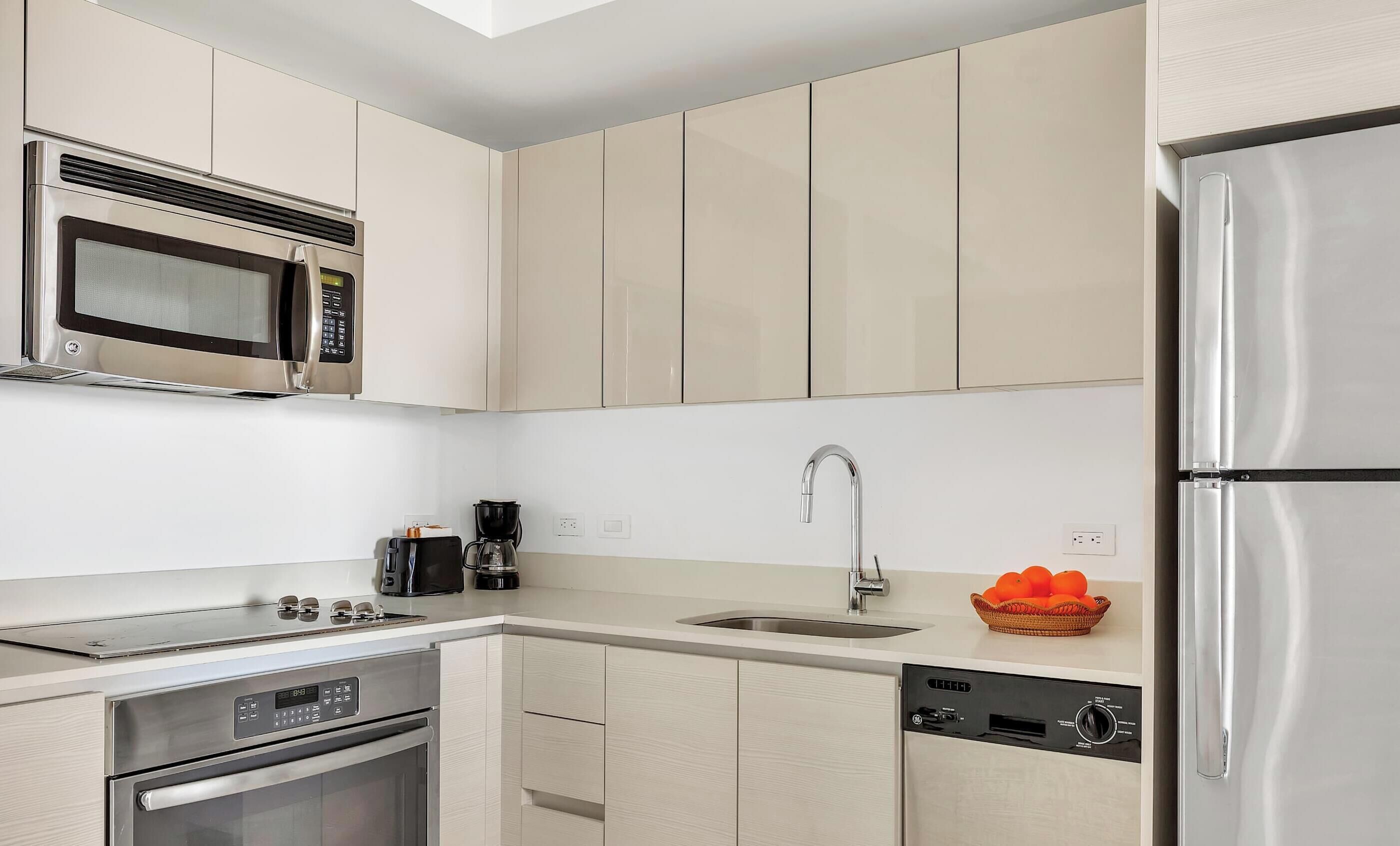 A modern kitchen with stainless steel appliances, a dishwasher, and a coffee maker.