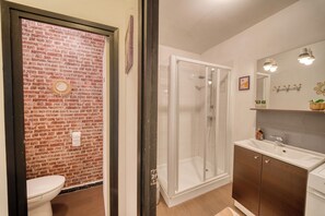 A bathroom with a shower, toilet, and sink.