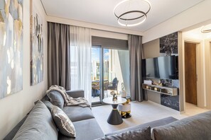 Una sala de estar moderna con un sofá, una mesa de centro y un televisor montado en la pared.