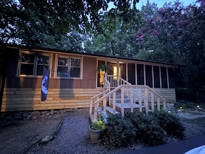 A wooden cabin with a porch and steps leading to a door. - Howling Hideaway - Woodland Retreat, 2 king beds, Hot tub (Mentone)