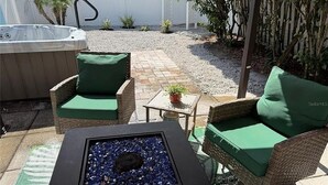 A patio area with a hot tub, wicker furniture, and a fire pit. - 3-bedroom cottage in adorable Mount Dora with AC comfort (Mount Dora)