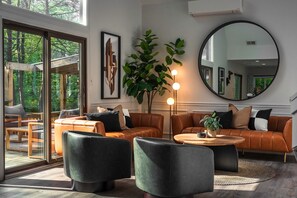 Ein modernes Wohnzimmer mit Ledersofas, einem runden Couchtisch und einem großen Spiegel.