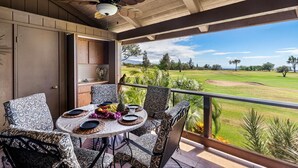 A balcony with a table set for dining, overlooking a golf course. - Waikoloa Villas#a203:top Floor Beauty, Ocean Views (Waikoloa)