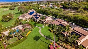 A residential area with houses, a golf course, and a large building with solar panels. - Waikoloa Villas#a203:top Floor Beauty, Ocean Views (Waikoloa)