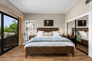 A modern bedroom with a large bed, a ceiling fan, and a view of the outdoors. - Royal Seacliff#401 (Kailua-Kona)