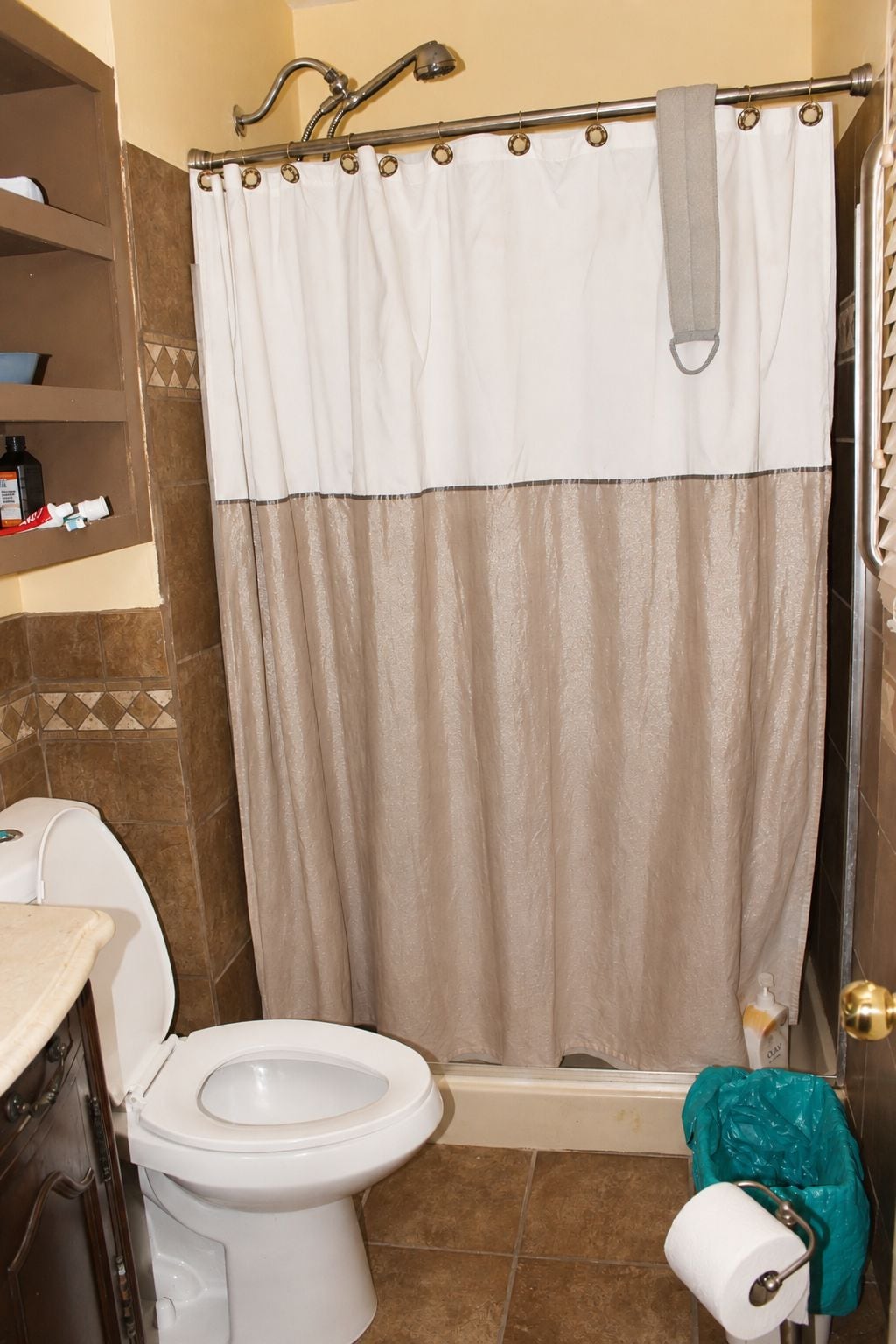 A bathroom with a shower curtain, a toilet, and a sink.