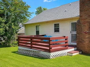 A house with a fenced deck, a brick exterior, and a window.