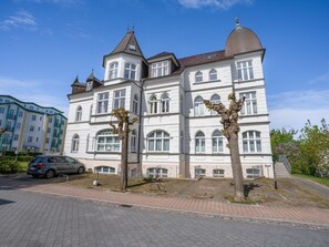Ein mehrgeschossiges Gebäude mit einer symmetrischen Fassade, großen Fenstern und einer zentralen Kuppel.