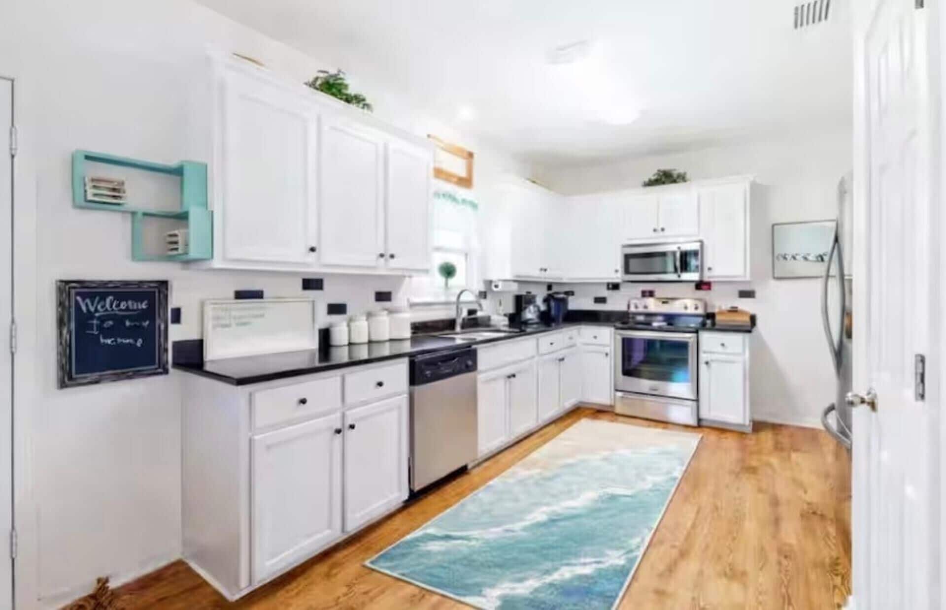 A modern kitchen with white cabinets, a microwave, an oven, and a dishwasher.