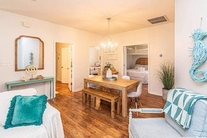 Un espacio habitable compacto con comedor, sofá, banca y cama.