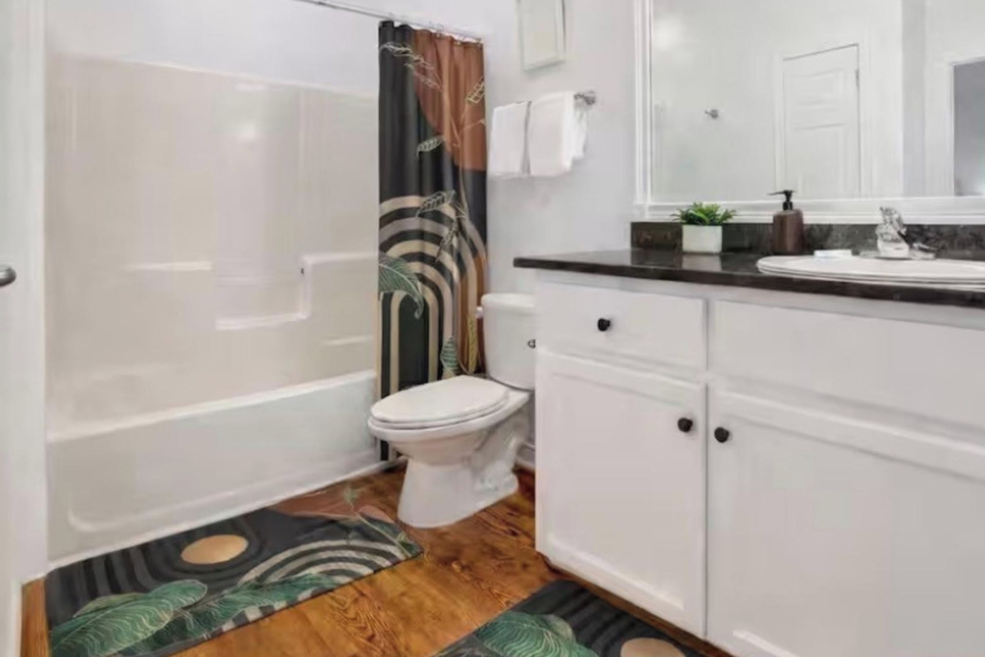 Un baño con bañera, inodoro y zona de lavamanos.