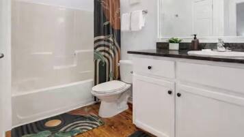 Un baño con bañera, inodoro y zona de lavamanos.
