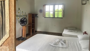 Quarto com duas camas, janela, ventoinha e prateleira.