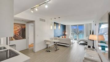 A modern living room with a sofa, a dining table, and pendant lighting.