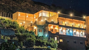 A multi-story building with balconies, under a starry night sky.