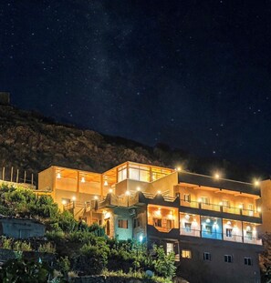 A multi-story building with balconies, under a starry night sky.