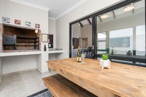A modern kitchen with a wooden countertop, a wine bottle, and glasses.
