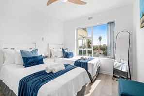 Una habitación de hotel con dos camas, un ventanal grande y vistas al exterior.