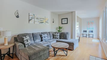 A modern living room with a sectional sofa, a round coffee table, and a small side table.