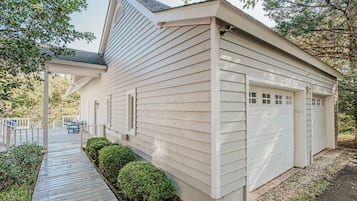 A single-story building with a covered porch, a garage, and a pathway leading to the entrance.