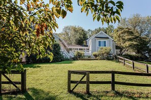 A house with a front porch, a covered entryway, and a fenced yard.