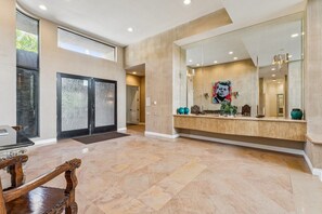 A spacious foyer with a large mirror, a wooden bench, and a modern reception desk. - 9th Hole Turn.  On the world famous Stadium Course!  Lake, Golf and MNT Views! (La Quinta)