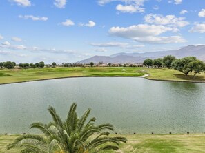 A golf course with a pond, palm trees, and distant mountains. - 9th Hole Turn.  On the world famous Stadium Course!  Lake, Golf and MNT Views! (La Quinta)