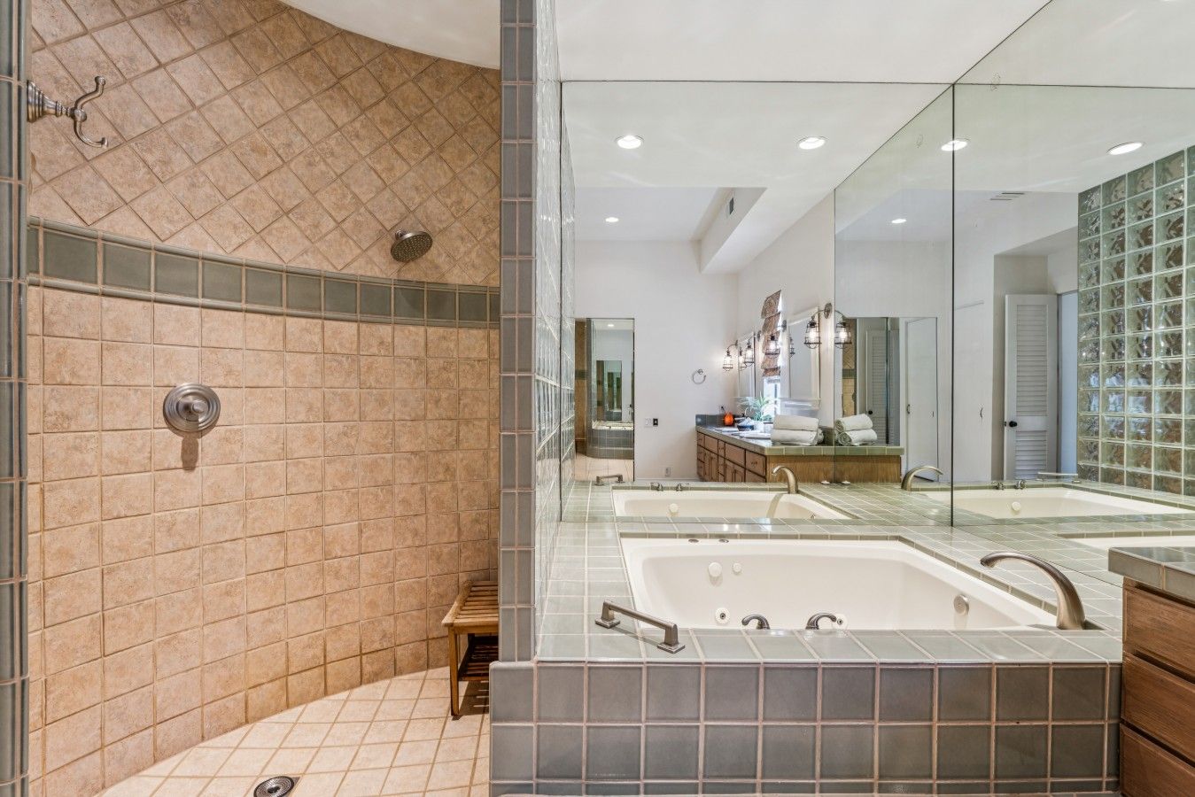 A modern bathroom with a walk-in shower, a large mirror, and a dual sink vanity.