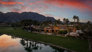 A modern house with a pool, surrounded by a well-maintained lawn and palm trees, with mountains in the background. - 9th Hole Turn.  On the world famous Stadium Course!  Lake, Golf and MNT Views! (La Quinta)