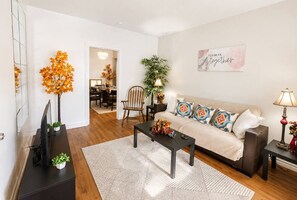 Una sala de estar con sofá, mesa de centro y plantas decorativas.