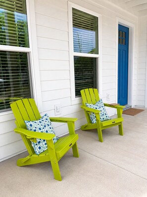 Two green Adirondack chairs with patterned cushions on a porch with white siding and a blue door. - Private Pool + New 4 Bedroom/4.5 Bath Home + Short Walk to the Beach (Panama City Beach)