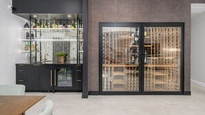 Eine moderne Bar mit Weinkühler und Flaschenregalen.