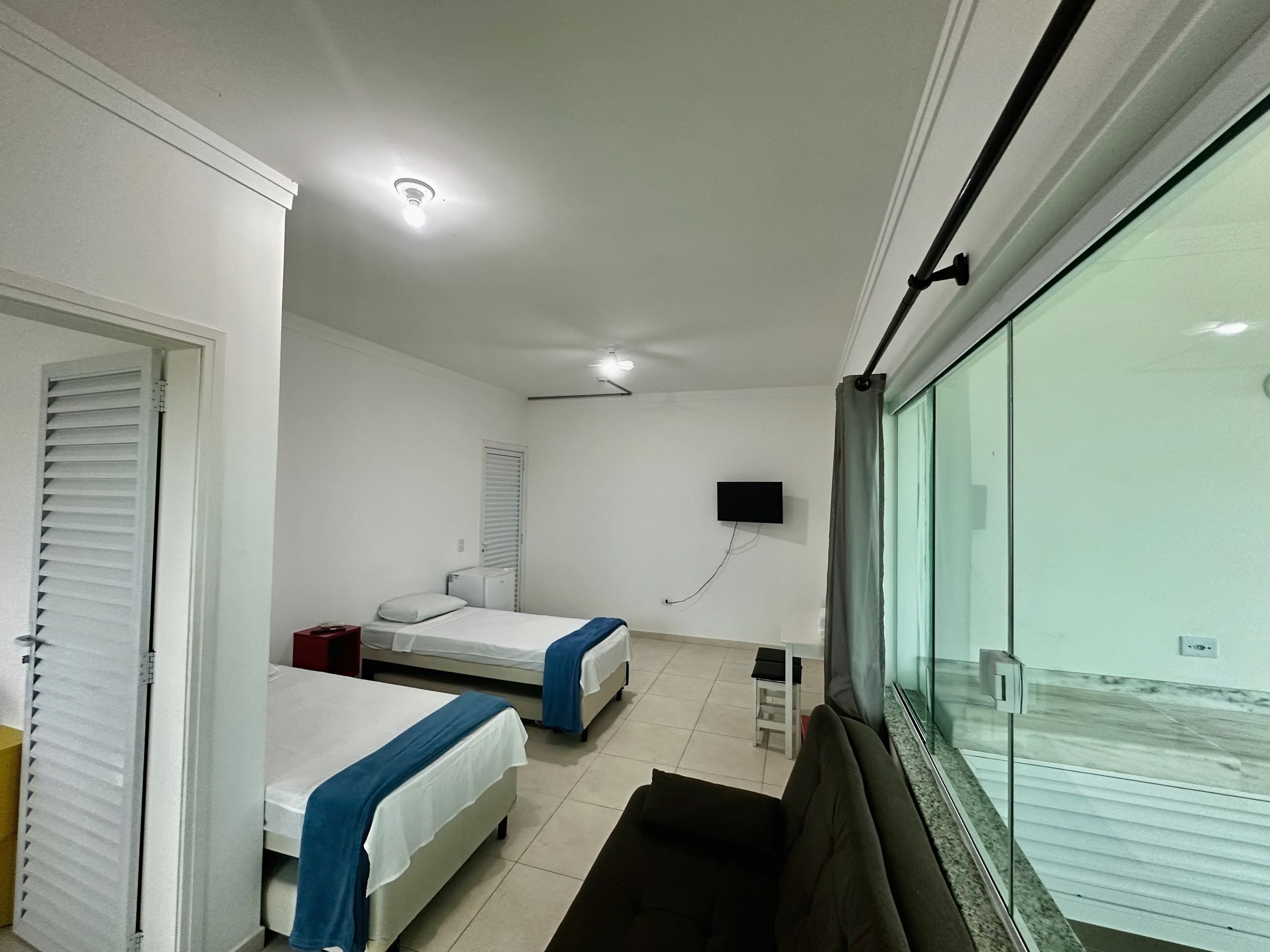 Habitación de hotel con dos camas, un televisor y una ventana con vistas.