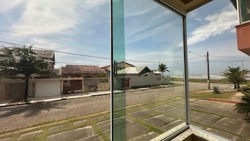 Rua residencial com casas, uma palmeira e céu claro.