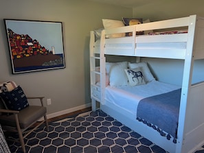 A bunk bed with a horse pillow, a framed picture on the wall, and a hexagonal patterned rug. - Charming 3-bedroom house in adorable Kenwood with cool vibes (Kenwood)