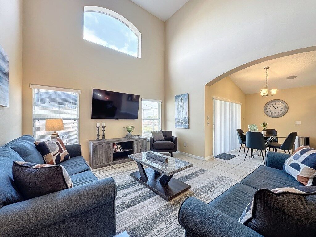A spacious living room with a large TV, comfortable seating, and a dining area.