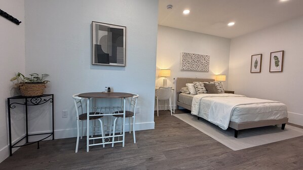 A bedroom with a bed, bedside tables, a lamp, and a wall-mounted mirror.