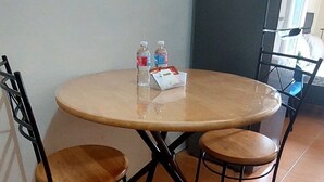 A round table with four chairs, two water bottles, and a small booklet on the table. - Cebu City Mabolo Resort Style (Cebu City)